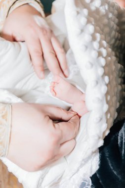 Kilisede çocuk vaftiz törenindeki küçük kız. Vaftiz töreni, vaftiz töreni. Bebeğin bacakları kapalı..