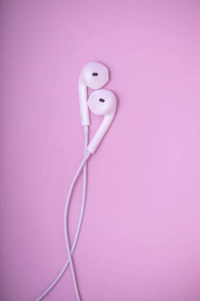 Lovely earphones. White earphones on pastel pink background. Music is my life concept. Valentine concept. World music day.