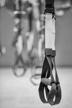 Kayışlar eğitim döngüsü ekipmanı. Gri arka planda siyah işlevsel eğitim ekipmanları. Spor aksesuarları. Sağlık için spor ve spor aletleri. Kendi ağırlık ile çalışmak için Trx fitness kayışları.