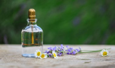 Aromaterapi şişede gerekli yağlar kırsal ahşap arka planda çiçekler. Parfüm, kozmetik, parfüm koleksiyonu..