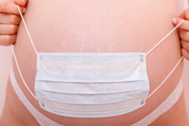 Covid 19 ncov koronavirüs ve salgın virüs belirtileri. Karnını kapat ve bebeği korumak için cerrahi maske tak. Karantinayı durdurun. Yüksek resulotion resmi.