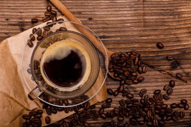 Eski ahşap arka planda kahve fincanı ve kahve çekirdekleri. Metin için kopyalama alanı olan üst görünüm. Yüksek resulotion resmi.