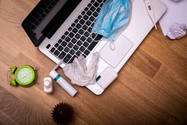 Office desk workspace homeoffice mock up with laptop, protective mask, gloves, white spray, thermometer, pills and medicine. Home office, Stay home. Covid-19 ncov or coronavirus concept.