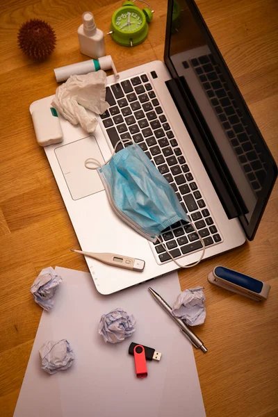 Office desk workspace homeoffice mock up with laptop, protective mask, gloves, white spray, thermometer, pills and medicine. Home office, Stay home. Covid-19 ncov or coronavirus concept.