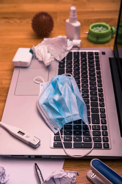 Office desk workspace homeoffice mock up with laptop, protective mask, gloves, white spray, thermometer, pills and medicine. Home office, Stay home. Covid-19 ncov or coronavirus concept.