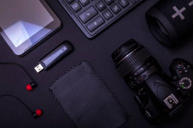 Dijital kamerası, hesap makinesi, USB sürücüsü ve fotokopi alanı olan siyah masa arkaplanı ile en iyi çalışma alanı fotoğrafçısı. Modern siyah aksesuarlar, minimal tasarım araçları.