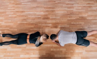 Çift ya da antrenör spor salonunda tahta hareketleriyle egzersiz yapıyor ya da öğretiyor. Metin için kopyalama alanı olan düz ya da üst görünüm. Yüksek resulotion resmi.