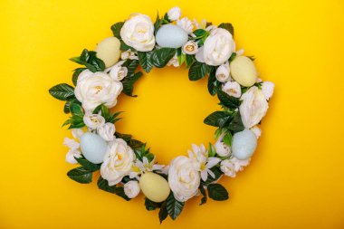 Sarı arka planda izole edilmiş renkli bir Paskalya yumurtası çelengi. Metinler için kopyalanmış Paskalya tatili konsepti. Yüksek resulotion resmi.