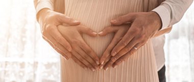 Hamile kadınlar kollarını karın çevresine kalp şeklinde sararlar. Aile kavramı. Yüksek resulotion resmi.