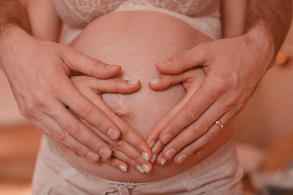 Großaufnahme Von Mann Und Frau Hand Die Herzform Auf Schwangerem — Stockfoto