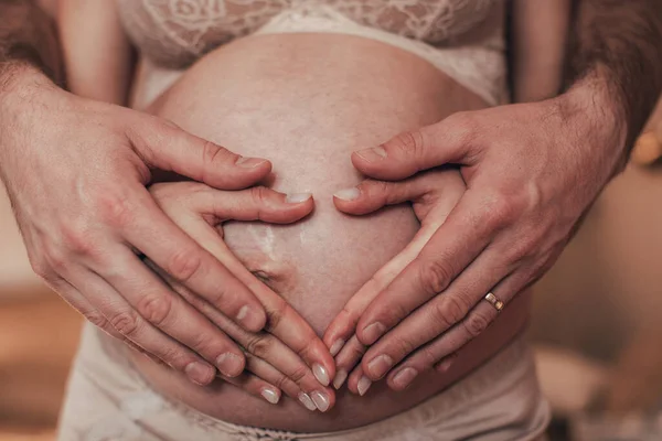 Großaufnahme Von Mann Und Frau Hand Die Herzform Auf Schwangerem — Stockfoto