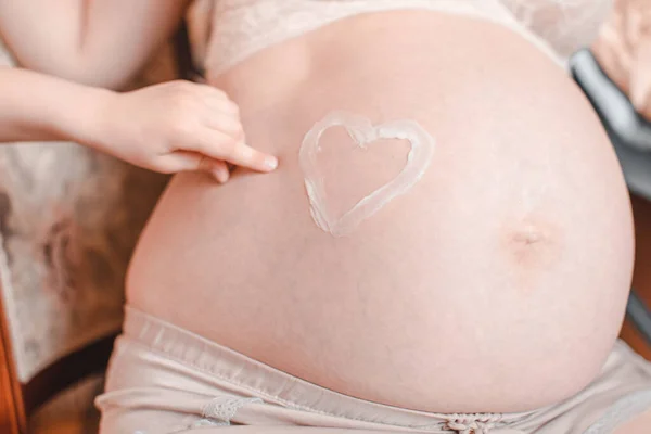 Forma Cuore Dipinto Con Crema Sulla Pancia Della Donna Incinta — Foto Stock