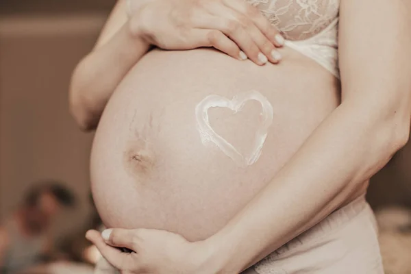 Eine Nahaufnahme Des Bauches Einer Schwangeren Frau Mit Einem Herz — Stockfoto