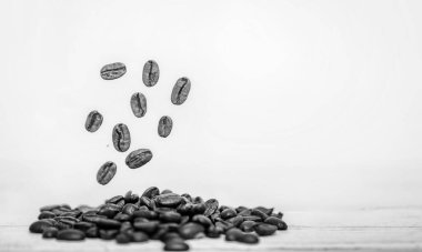 Uçan kahve çekirdekleri. Düşen kahve çekirdekleri beyaz üzerine izole edilmiş. Kafe menüsü veya broşür şürü. Küçük bir alan derinliğiyle doğal lens bulanıklığı.