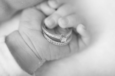 Bebek eli. Yeni doğan eller alyansları tutuyor. Aile ve aşk kavramı. Resmi kapat.