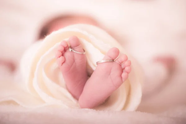 暖かい白いウールの敷物の中でお母さんの結婚指輪と新生児の足 幸せな家族の概念 マタニティの美しい概念的なイメージ 画像を閉じる — ストック写真