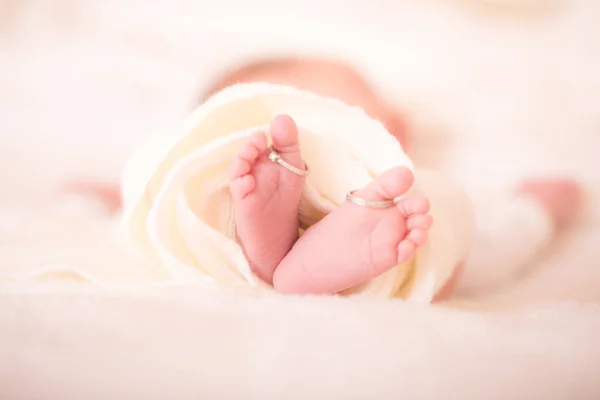 新生児の足と彼の両親の結婚指輪 暖かい白いウールの敷物の中でお母さんの結婚指輪と新生児の足 幸せな家族の概念 マタニティの美しい概念的なイメージ 画像を閉じる — ストック写真