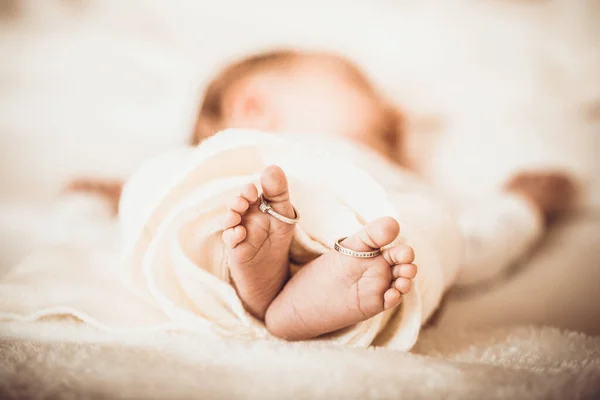 赤ん坊の足は2つのリングで接近した 結婚指輪と新生児の足の閉鎖 家族の概念 画像を閉じる — ストック写真
