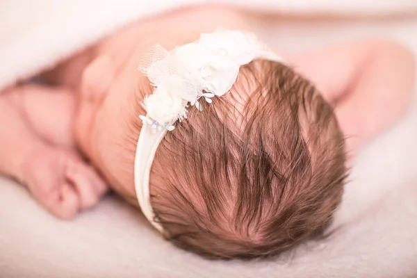 一个睡在白色床上的漂亮小宝宝的特写 新出生的女孩睡在白色针织毛毯下 近景图像 — 图库照片