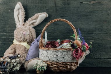 Süslü yumurtalı Paskalya sepeti ve ahşap arka planda peluş tavşan. Yüksek resulotion resmi.