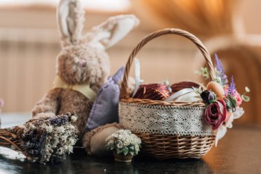 Süslü yumurtalı Paskalya sepeti ve ahşap arka planda peluş tavşan. Yüksek resulotion resmi.