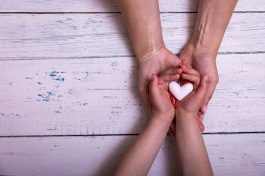 Anneler Günü kutlaması, ebeveyn kadınlarıyla birlikte küçük çocukların ellerini tutuyor. Kalbe destek oluyor, çocuk evlat edinme ve ebeveynlik için bağış yapıyor, aile sağlığı kavramını kullanıyor. Yüksek resulotion resmi.