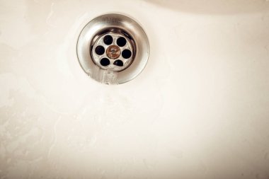 Lavabonun arka planında su boşaltılıyor. Lavaboda akan su gideri. Yüksek resulotion resmi.