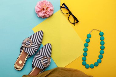 Moda seti. Pastel arka planda güneş gözlüklü ayakkabılar. Üst görünüm.