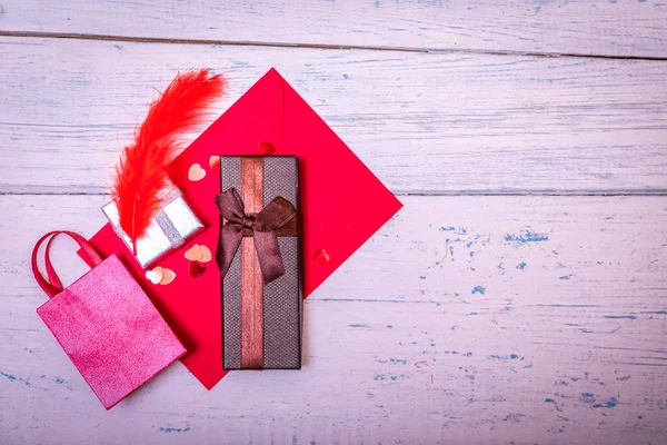 Red envelope or letter, gift, paper card on rustic wooden table for greeting on Mother or Woman Day. Empty copy space for text or greating. High resulotion image.