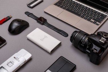 Dijital kamera, harici sabit diski olan usb ya da gri kağıt arka planda profesyonel fotoğrafçının bataryası ve ekipmanı. Tasarımcı iş yeri konsepti. Yüksek resulotion resmi.
