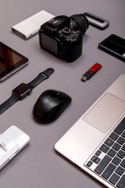 Dijital kamera, harici sabit diski olan usb ya da gri kağıt arka planda profesyonel fotoğrafçının bataryası ve ekipmanı. Tasarımcı iş yeri konsepti. Yüksek resulotion resmi.