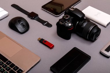 Dijital kamera, harici sabit diski olan usb ya da gri kağıt arka planda profesyonel fotoğrafçının bataryası ve ekipmanı. Tasarımcı iş yeri konsepti. Yüksek resulotion resmi.