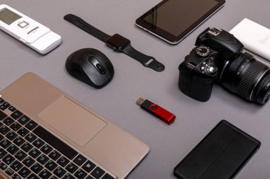 Dijital kamera, harici sabit diski olan usb ya da gri kağıt arka planda profesyonel fotoğrafçının bataryası ve ekipmanı. Tasarımcı iş yeri konsepti. Yüksek resulotion resmi.