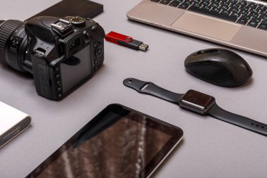 Dijital kamera, harici sabit diski olan usb ya da gri kağıt arka planda profesyonel fotoğrafçının bataryası ve ekipmanı. Tasarımcı iş yeri konsepti. Yüksek resulotion resmi.