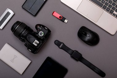 Dijital kamera, harici sabit diski olan usb ya da gri kağıt arka planda profesyonel fotoğrafçının bataryası ve ekipmanı. Tasarımcı iş yeri konsepti. Yüksek resulotion resmi.