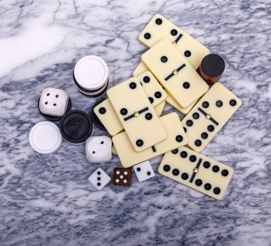 Oyunların karışımı kapanıyor. Eski bir mermer masa arka planında çeşitli masa oyunları zarları ve dominolar. Yüksek resulotion resmi.