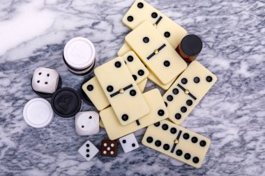 Oyunların karışımı kapanıyor. Eski bir mermer masa arka planında çeşitli masa oyunları zarları ve dominolar. Yüksek resulotion resmi.