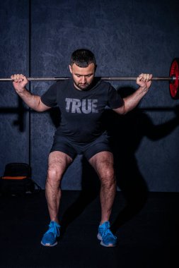 Spor salonunda halter kaldıran genç bir adam. Ön manzara. Güçlü ve sağlıklı yaşam tarzı konsepti. Yüksek resulotion resmi.
