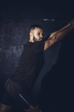 Spor salonunda trisepsler için egzersiz yapan sakallı adam. Spor salonunda yakışıklı, güçlü bir sporcu antrenmanı ve barfiks çekiyor. Yüksek resulotion resmi.