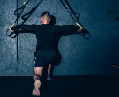 Spor salonunda jimnastik yaparken askıya alınmış jimnastik kayışları, antrenman bacakları. Alt vücut egzersizi. Yüksek resulotion resmi.