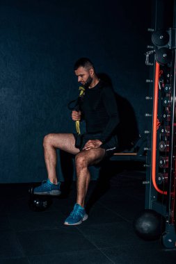 Yüksek resülosyon görüntüsü. Sakallı yakışıklı fitness adamı spor salonunda rahatça oturuyor. Keyifli bir şekilde telif hakkı motivasyonu. Spor yaşam tarzı, mutluluk, aktif insanlar konsepti..