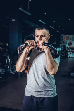 Crossfit eğitimi. Fitness adamı ağırlık çalışması yapıyor. Kettlebell kaldırarak. Kettlebell salıncakları yapan genç bir atlet. Vücut geliştirici, çaydanlık çanı kaldırıyor. Jimnastik hocası..