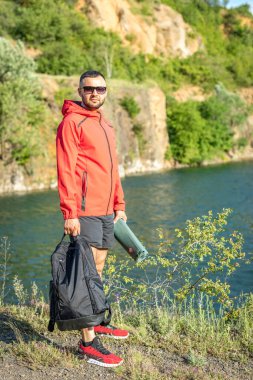 Sonbaharda ya da Quarry Gölü 'ndeki bahar manzaralı kırmızı ceketli yakışıklı adam fotoğrafı..