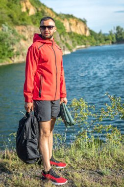 Sonbaharda ya da Quarry Gölü 'ndeki bahar manzaralı kırmızı ceketli yakışıklı adam fotoğrafı..