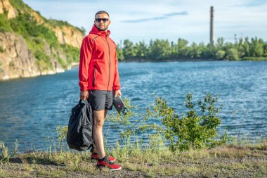 Sonbaharda ya da Quarry Gölü 'ndeki bahar manzaralı kırmızı ceketli yakışıklı adam fotoğrafı..