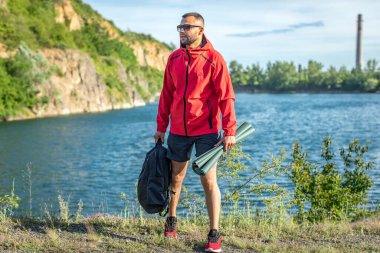 Sonbaharda ya da Quarry Gölü 'ndeki bahar manzaralı kırmızı ceketli yakışıklı adam fotoğrafı..