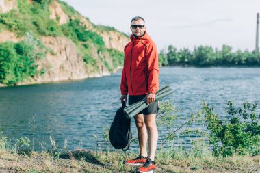 Sonbaharda ya da Quarry Gölü 'ndeki bahar manzaralı kırmızı ceketli yakışıklı adam fotoğrafı..