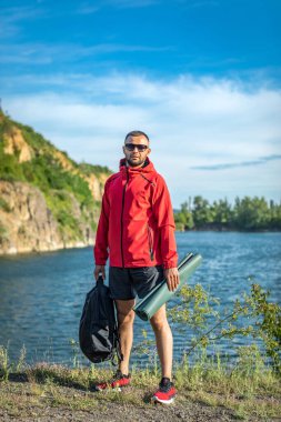 Sonbaharda ya da Quarry Gölü 'ndeki bahar manzaralı kırmızı ceketli yakışıklı adam fotoğrafı..