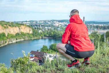 Quarry Gölü 'nde genç ve çekici sakallı bir adam manzaranın tadını çıkarıyor. Hafta sonu konseptinde kamp gezisi.
