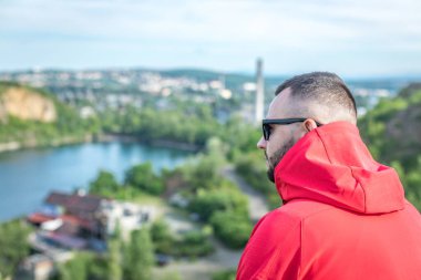 Quarry Gölü 'nde genç ve çekici sakallı bir adam manzaranın tadını çıkarıyor. Hafta sonu konseptinde kamp gezisi.